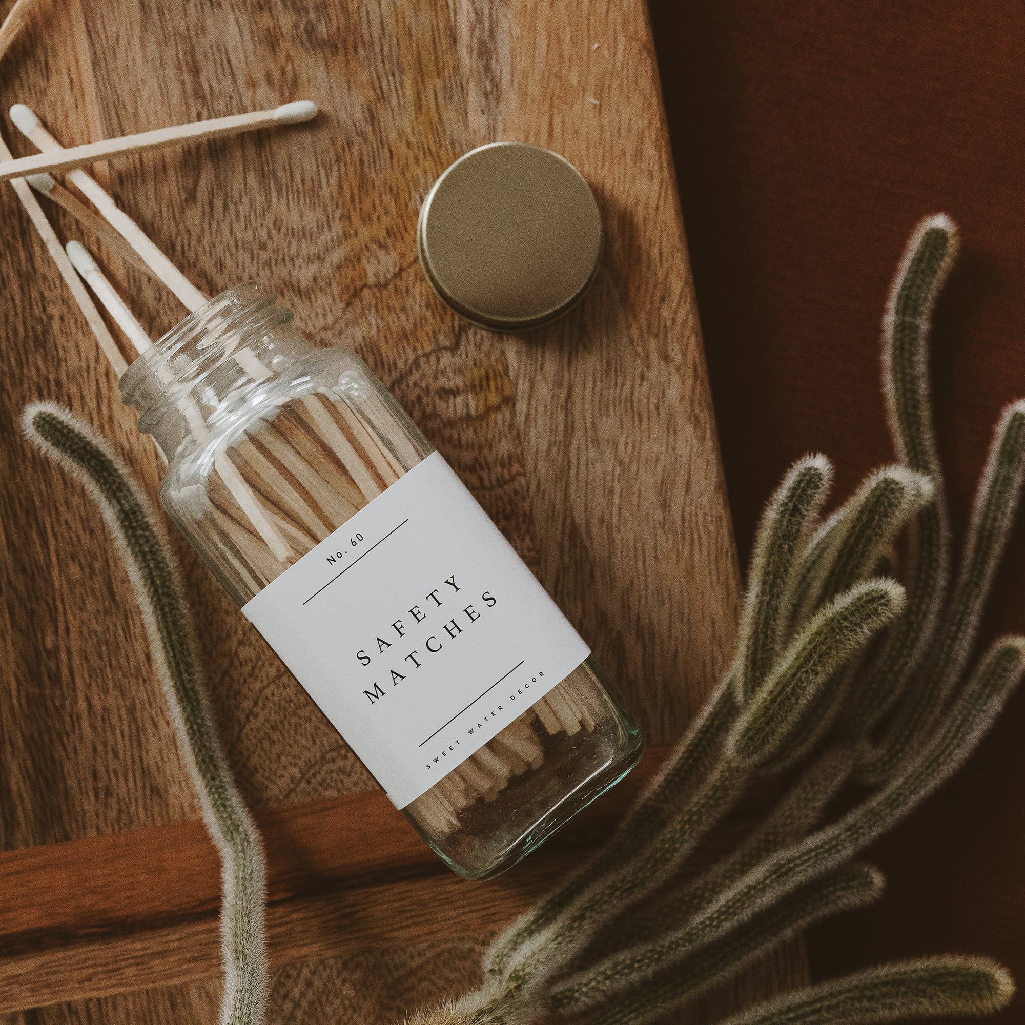 Safety matches jar styled beside candle on counter